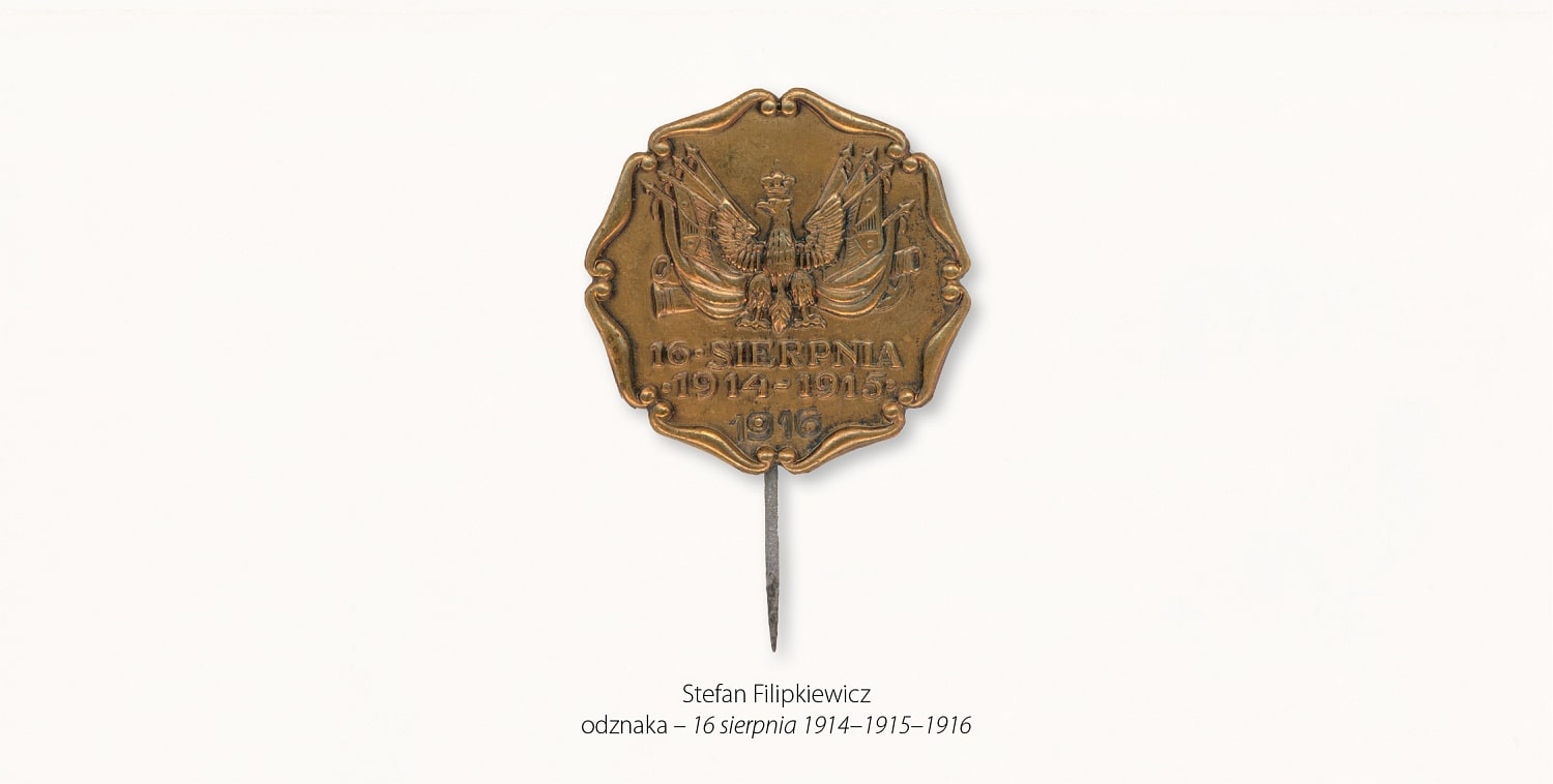 Odznaka- w formie ośmioboku o dekoracyjnie opracowanych brzegach. Przedstawia Orła w koronie, poniżej którego widnieje napis: 16 sierpnia 1914-1915-1916.